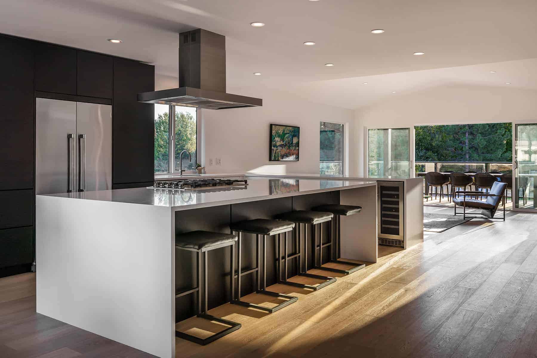 Modern kitchen with a large island with matching black stools tucked inside the table